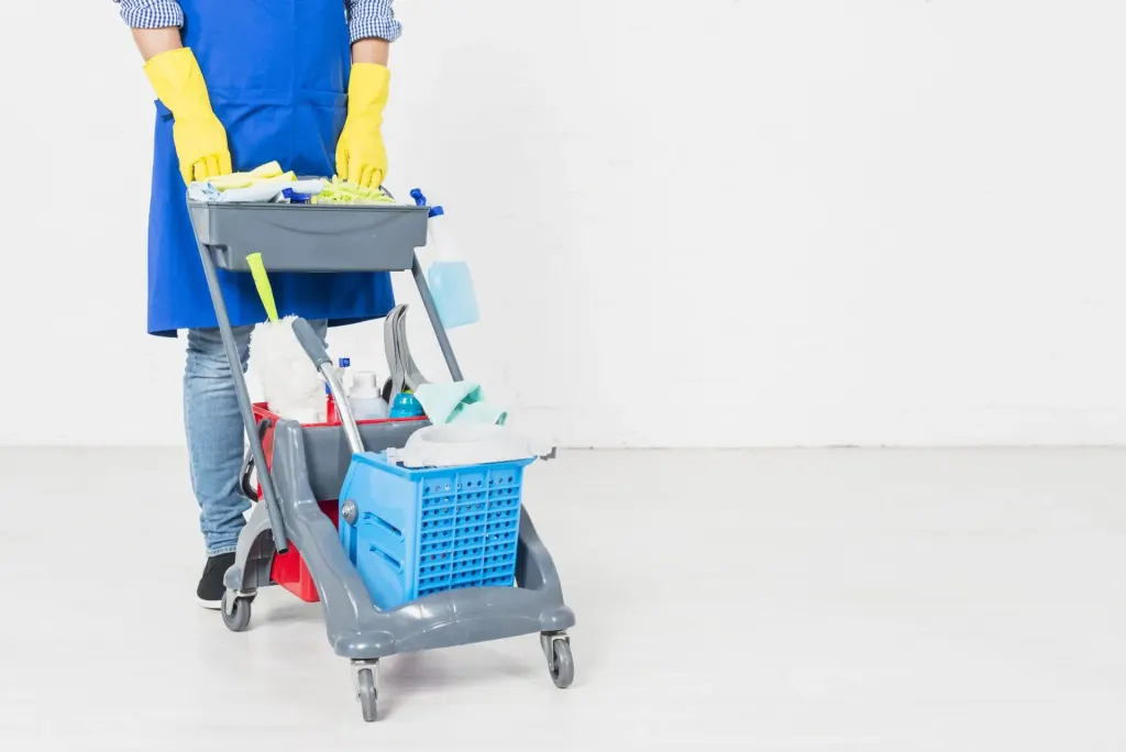 Operatrice delle pulizie con carrello attrezzato